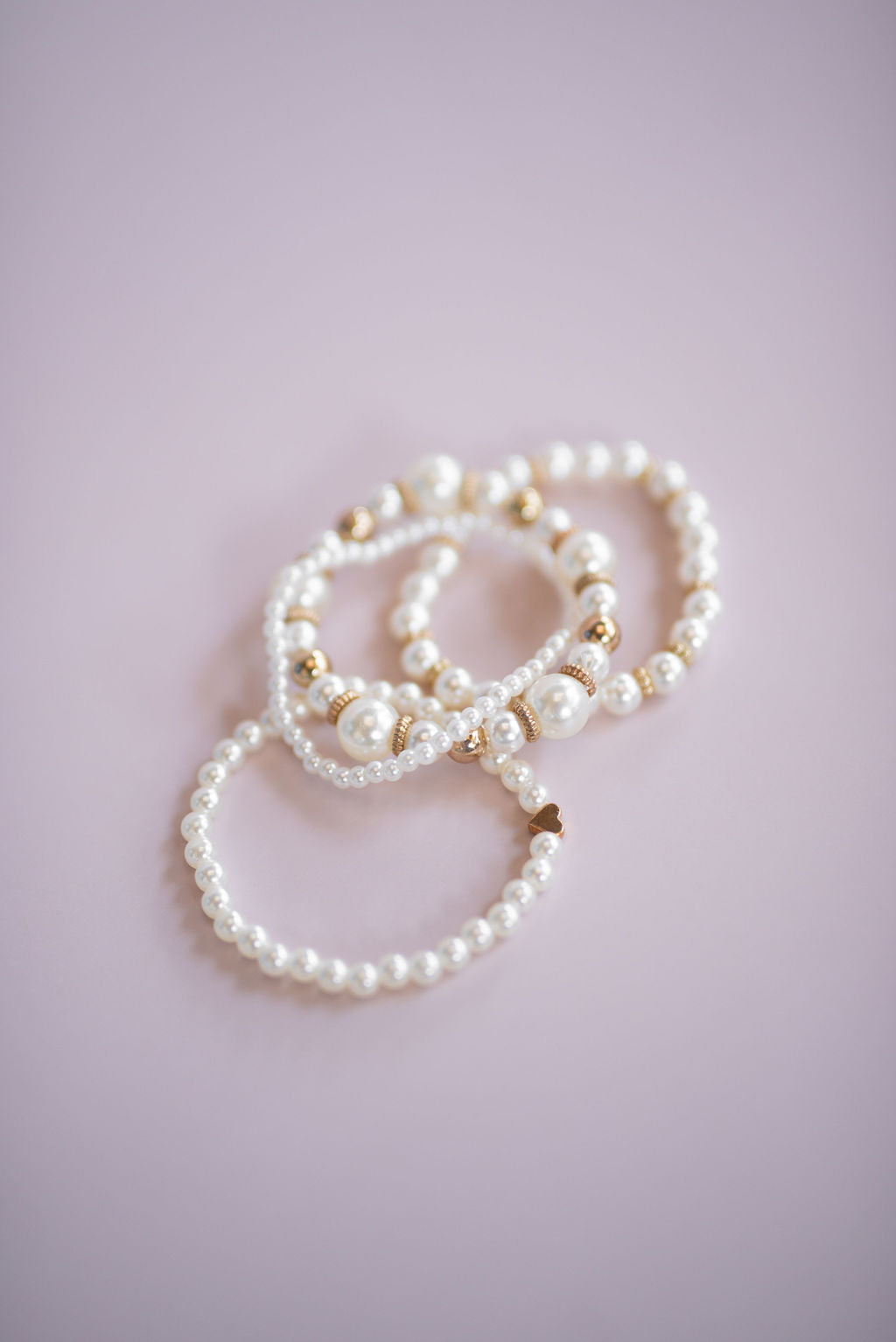 Close-up of stacked faux pearl bracelets showing elegant layered bridal jewellery style.