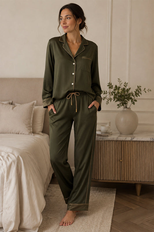 Missosca olive green luxury pyjama set with gold piping, worn by a woman in a neutral bedroom.