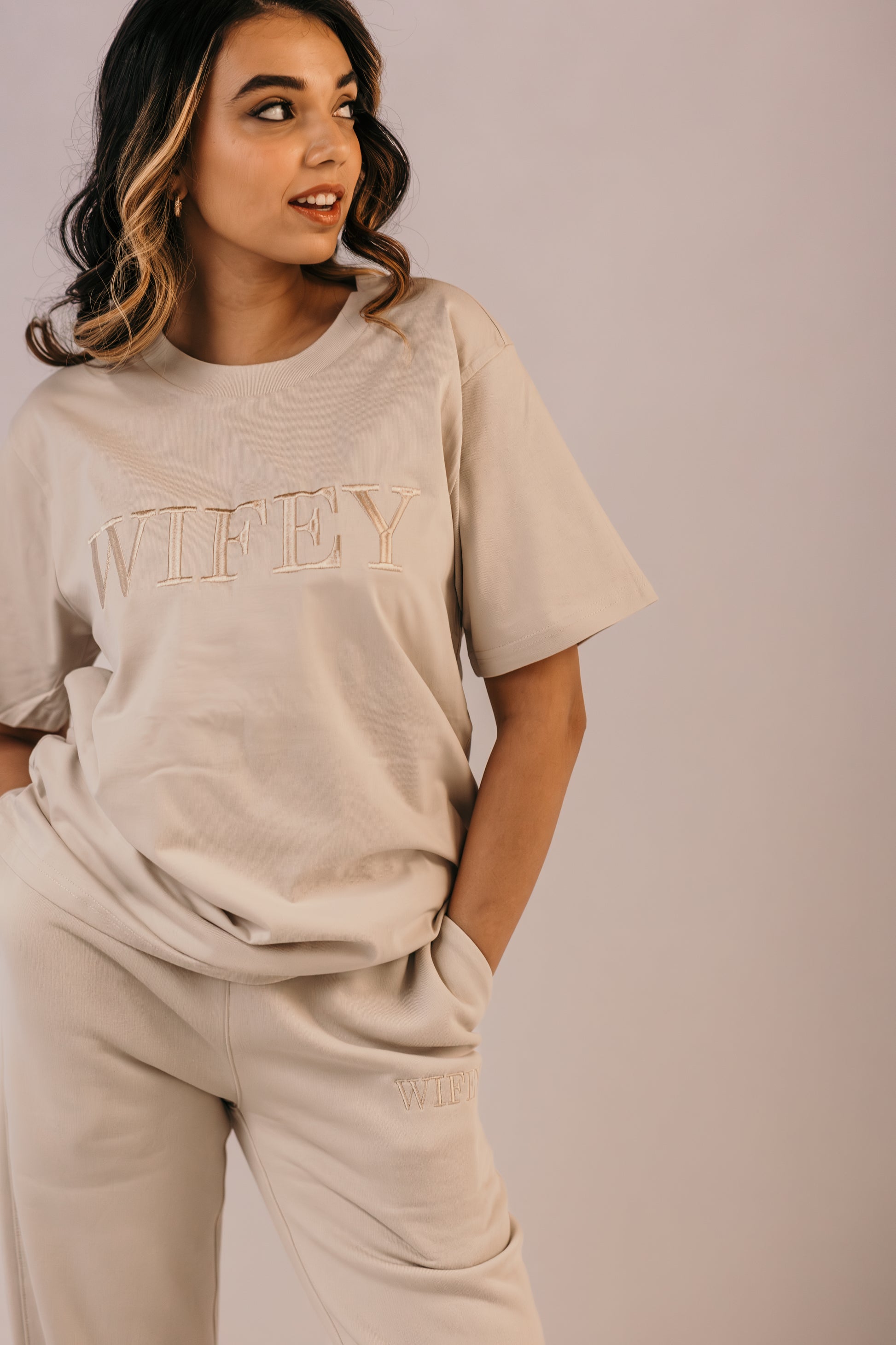 Bride wearing wifey track pants full outfit neutral tone loungewear
