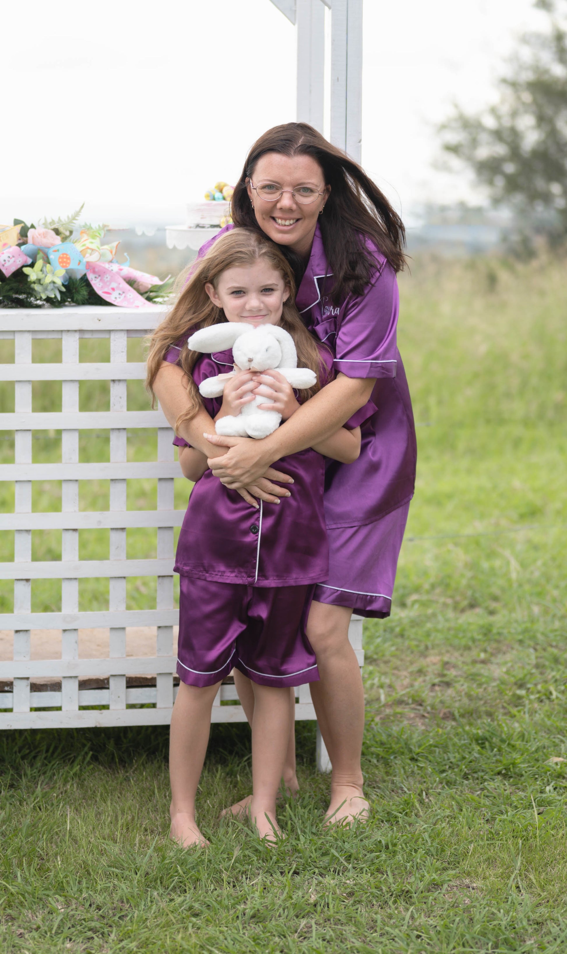 Close-up of purple satin pyjama fabric with white piping detail