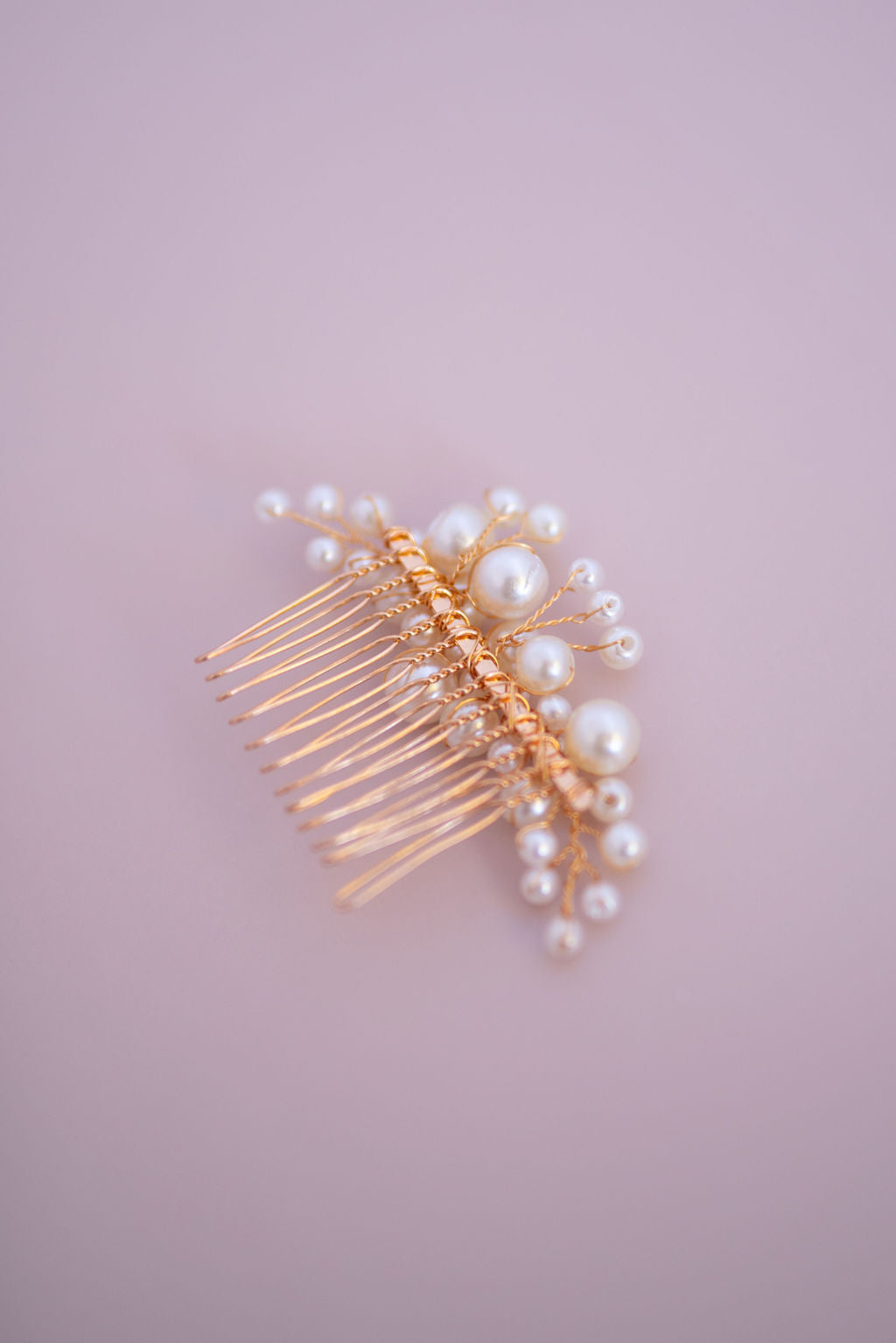 Pearl hair comb placed on pastel background styled as bridal accessory