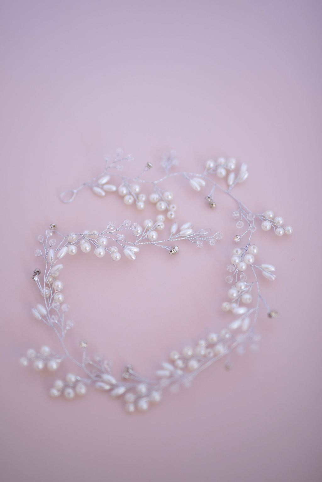 Silver bridal hair vine displayed in flat lay, delicate wedding hair accessory.