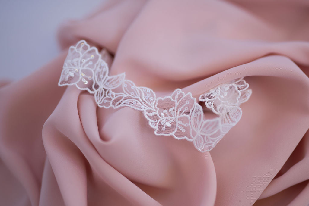 Detailed view of elegant bridal garter showing lace texture and shimmer finish.
