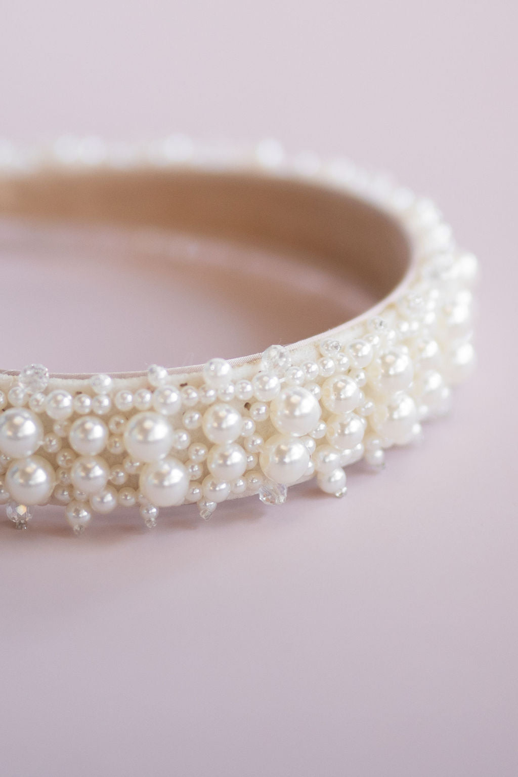 Top angle of elegant pearl headband bridal hair accessory on neutral background