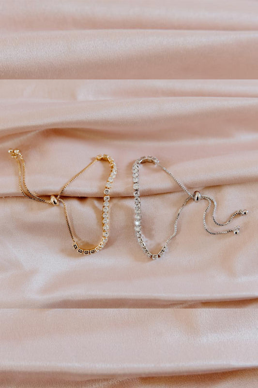 Gold and silver chain bracelets styled on soft fabric background elegant minimalist jewellery