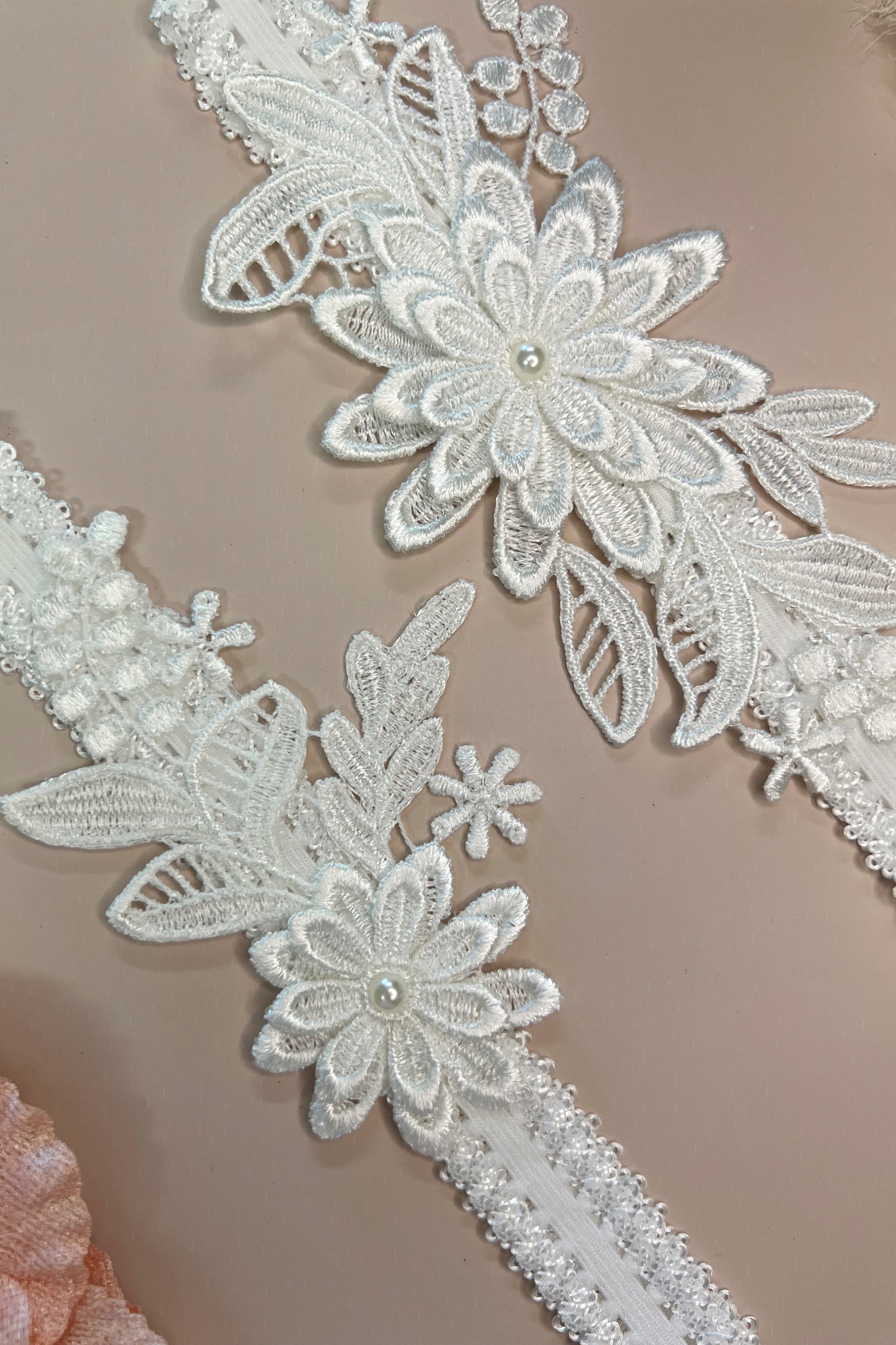 Close-up of floral lace bridal garter set showing delicate detailing and soft stretch design.