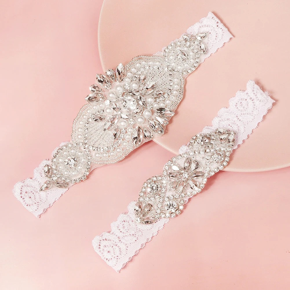 Close-up of pearl and diamante bridal garter set showing intricate floral lace detailing.