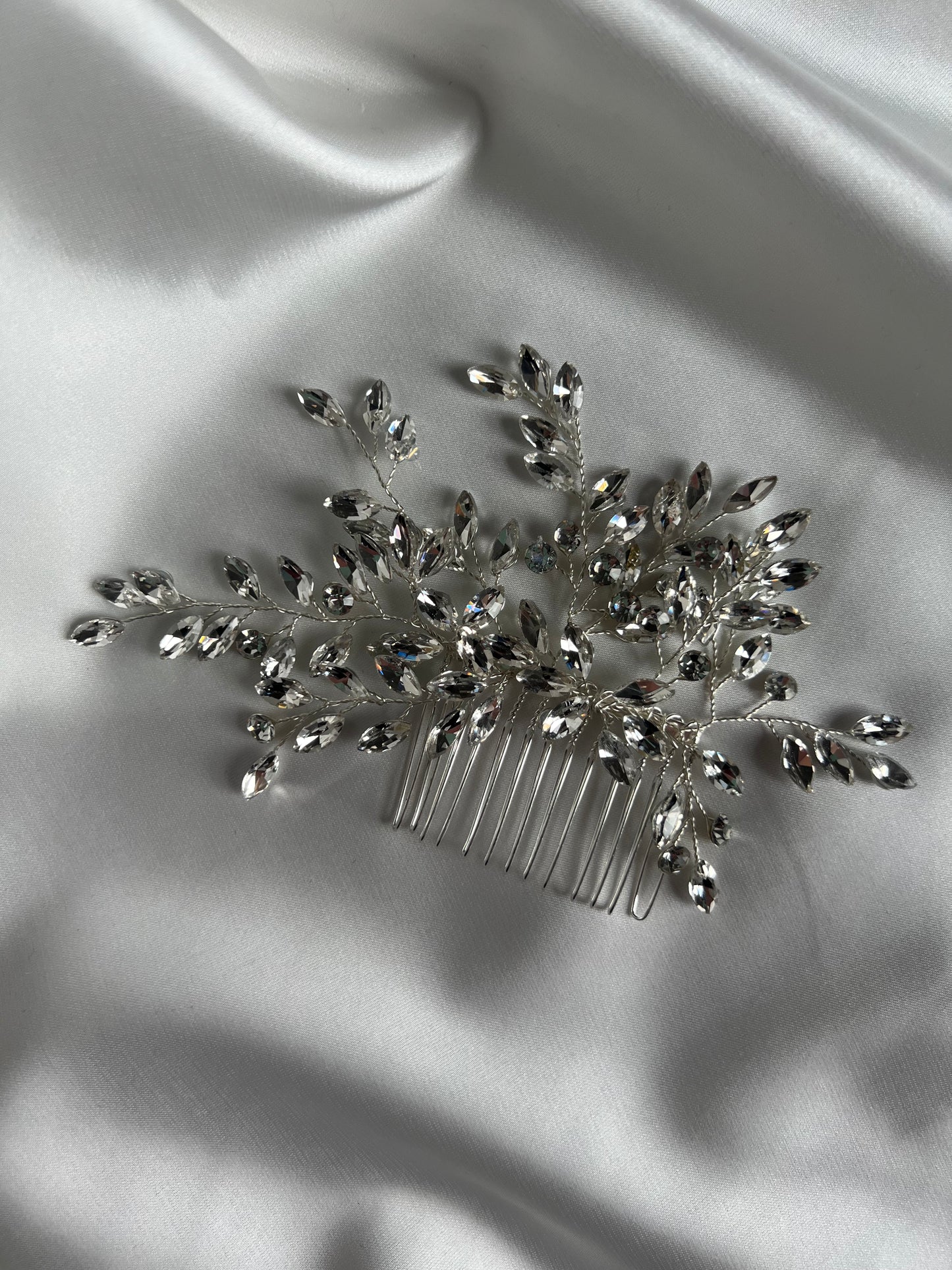Crystal wedding hair comb styled on soft satin fabric for elegant bridal presentation.
