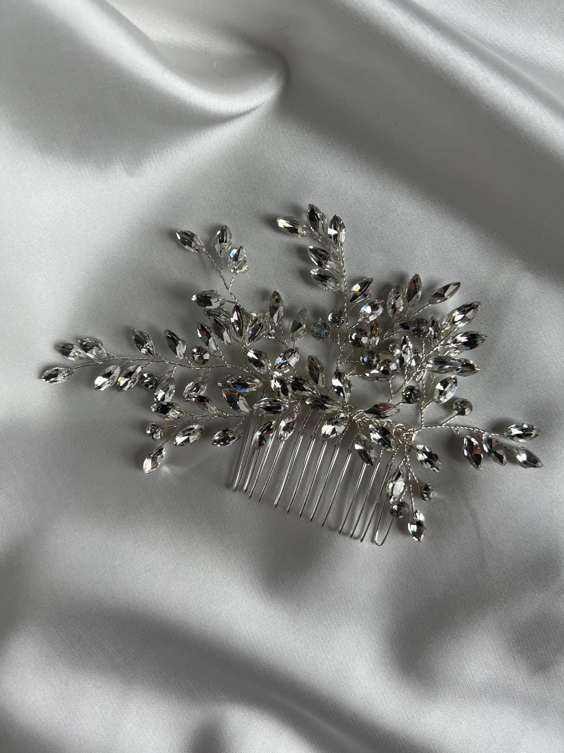 Crystal wedding hair comb styled on soft satin fabric for elegant bridal presentation.