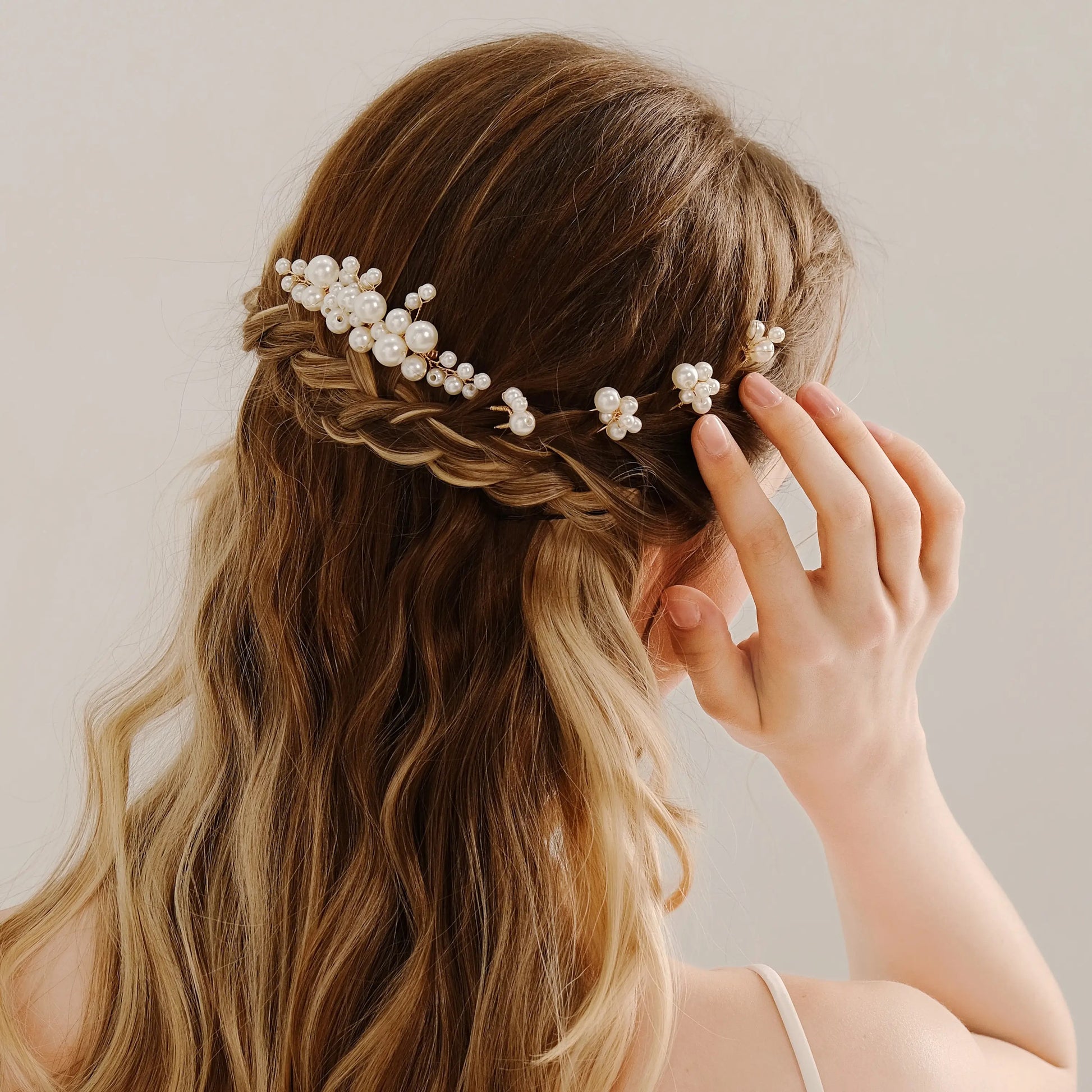 Bride wearing pearl hair comb set styled into soft wedding hairstyle

