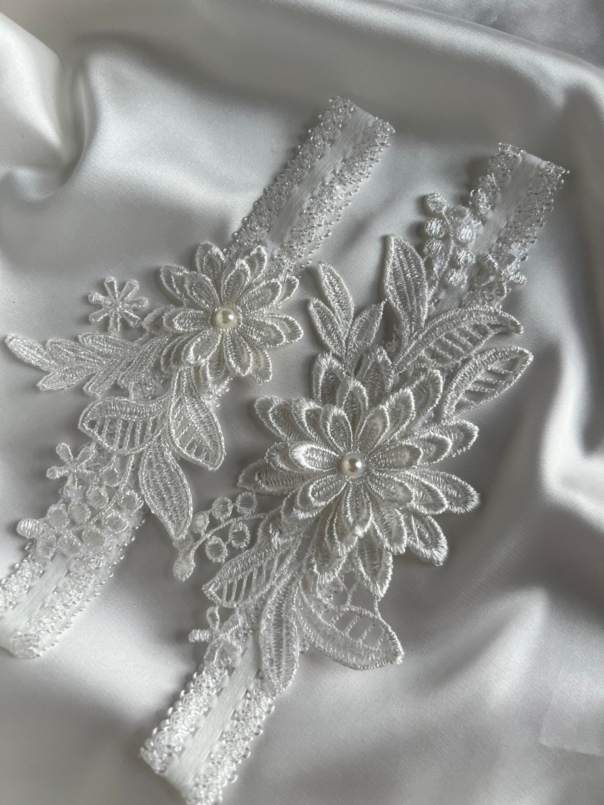 Romantic lace bridal garter set styled for wedding day preparation and bridal photos.