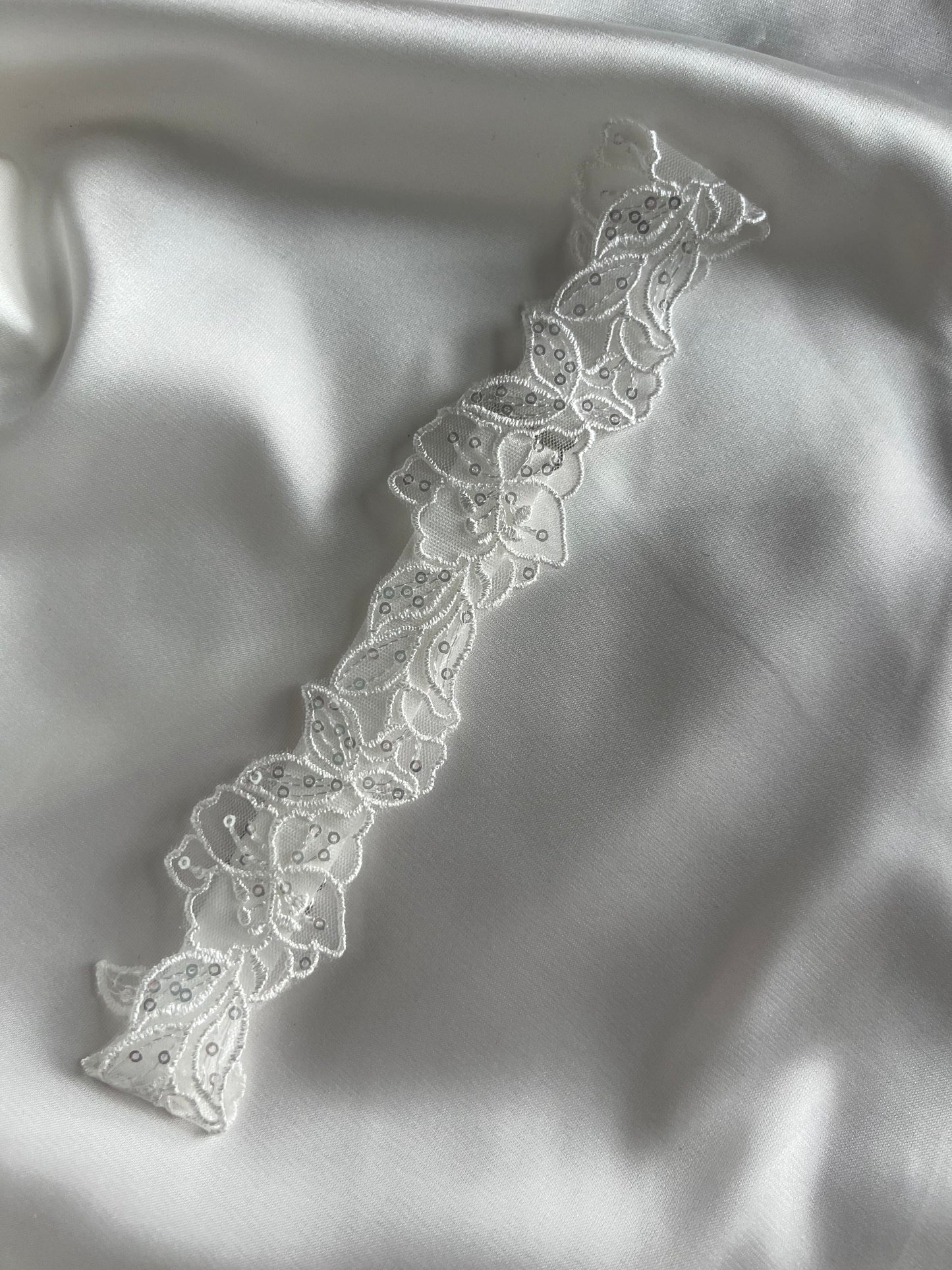 Romantic bridal garter accessory styled for wedding morning preparation.