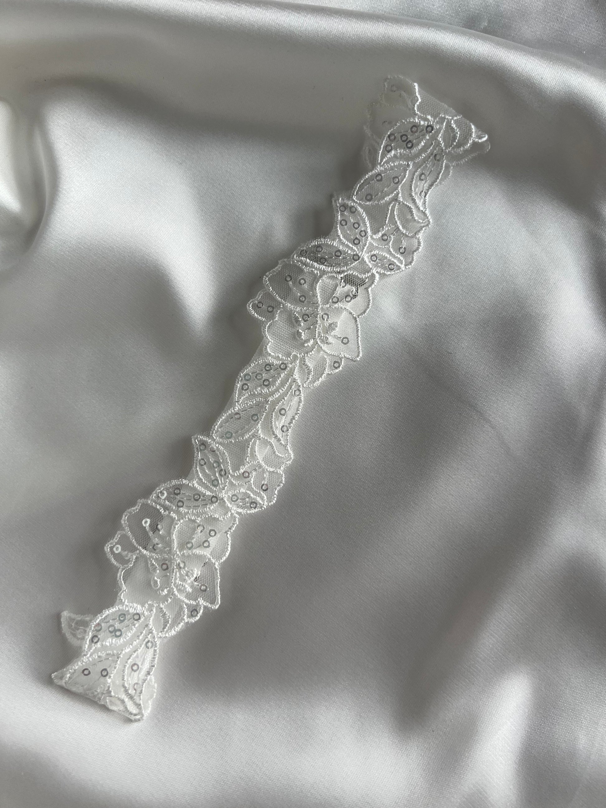 Romantic bridal garter accessory styled for wedding morning preparation.