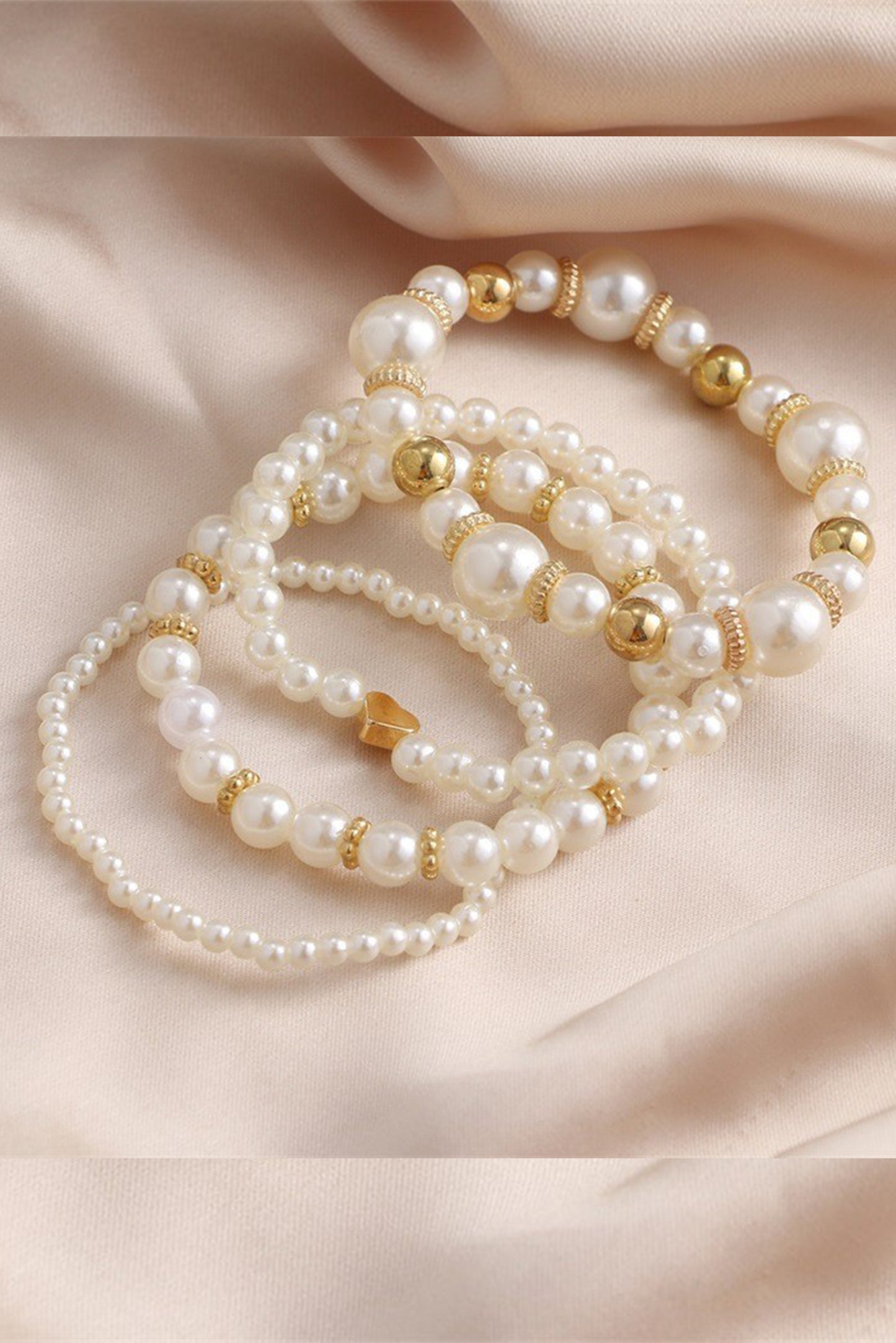 Faux pearl bracelet set styled on soft fabric, timeless wedding and formal occasion jewellery.