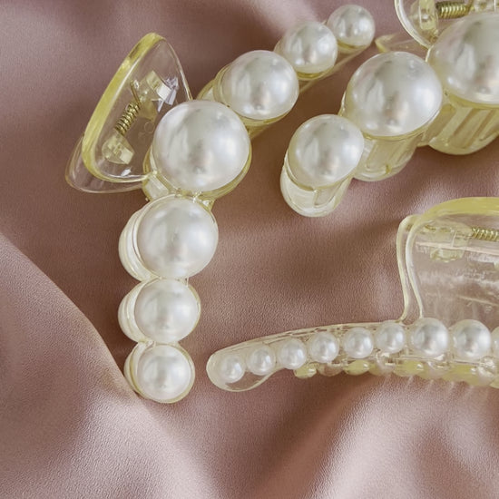 Elegant pearl hair clips styled in hair for bridal and formal occasion hairstyles.