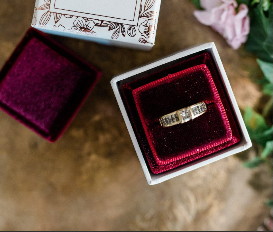 Engagement ring displayed inside luxury square velvet ring box with soft plush lining.